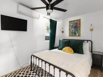 a bedroom with a bed and a flat screen tv at Barrio Casita - 2Bd, Central, Parking, EV Charging in San Diego