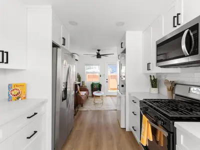 a kitchen with white cabinets and a stove top oven at Barrio Casita - 2Bd, Central, Parking, EV Charging in San Diego