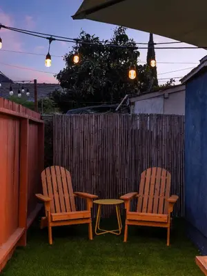 two chairs and a table in a backyard with a fence at Barrio Casita - 2Bd, Central, Parking, EV Charging in San Diego