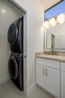 a laundry room with a washer and dryer next to a mirror at The 357 Beach Pad, Renovated, Refined, Steps from the Surf! in San Diego