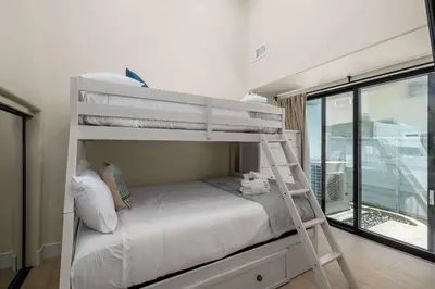 a bunk bed in a room with a ladder at The 357 Beach Pad, Renovated, Refined, Steps from the Surf! in San Diego