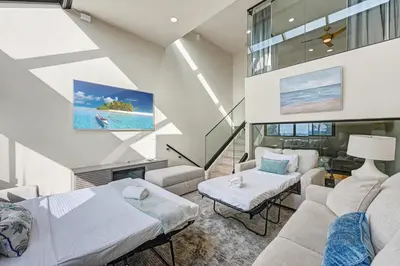 a large living room with a couch and a tv at The 357 Beach Pad, Renovated, Refined, Steps from the Surf! in San Diego