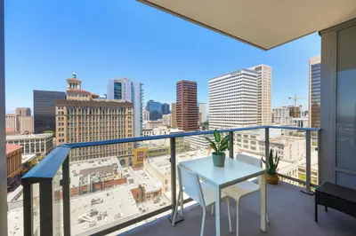 a balcony with a table and a view of the city at NEW Upscale Downtown San Diego Stay Queen Bed Pool & Sauna in San Diego