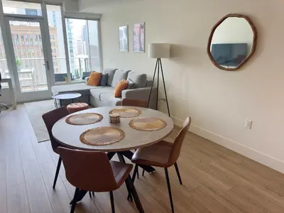 a living room with a table and chairs and a mirror at NEW Upscale Downtown San Diego Stay Queen Bed Pool & Sauna in San Diego
