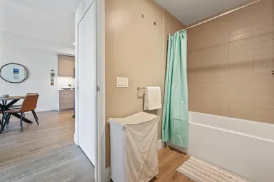 a bathroom with a tub and a shower with a table at NEW Upscale Downtown San Diego Stay Queen Bed Pool & Sauna in San Diego