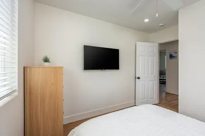 a bedroom with a bed and a tv on a wall at Beautiful cozy home in San Diego in San Diego