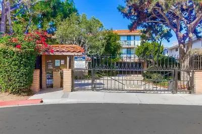 a gate in front of a building with trees and flowers at Sandy Wheels - DMST66 in Solana Beach