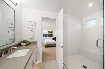 a white bathroom with a shower and a sink at La Jolla Panoramic Ocean Retreat with Rooftop in San Diego