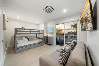 a bedroom with a bunk bed and a couch at La Jolla Panoramic Ocean Retreat with Rooftop in San Diego