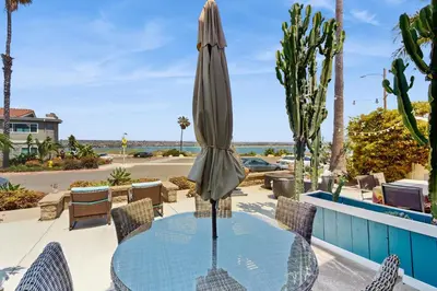 a patio with a glass table with a umbrella at Bayview Serenity Oceanfront in San Diego