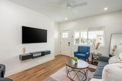 a living room with a couch and a tv on a wall at Modern home near Downtown San Diego in San Diego