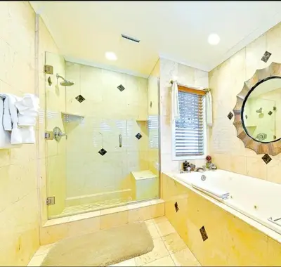 a bathroom with a shower and a tub and a sink at Spacious 5BD Ocean Views Pool Jacuzzi in San Diego