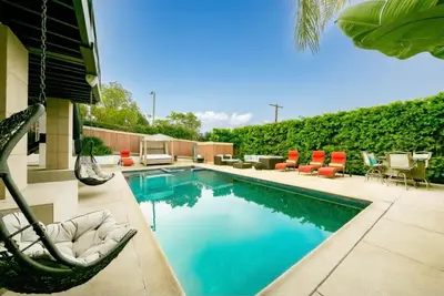 a swimming pool with chairs and a hammock next to a house at Spacious 5BD Ocean Views Pool Jacuzzi in San Diego