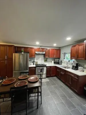 a kitchen with wooden cabinets and a table and chairs at Oasis Resort in Homeland