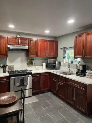 a kitchen with wooden cabinets and a sink and a table at Oasis Resort in Homeland