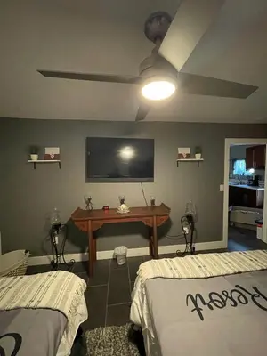 a room with two beds and a tv on the wall at Oasis Resort in Homeland