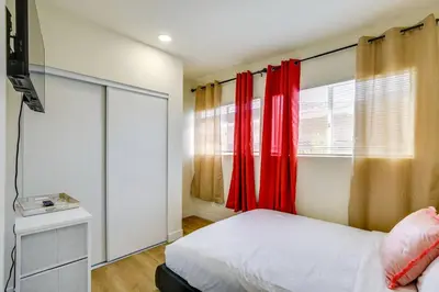 a bedroom with red curtains and a bed and a television at Nice and Comfortable for family in San Diego
