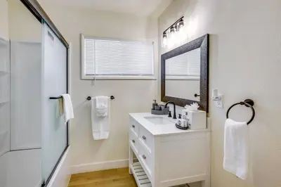 a white bathroom with a sink and a mirror at Nice and Comfortable for family in San Diego