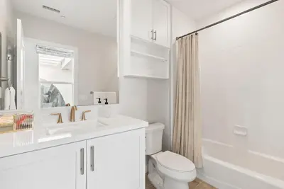 a white bathroom with a sink and a toilet at The Penthouse Oceanfront in Oceanside