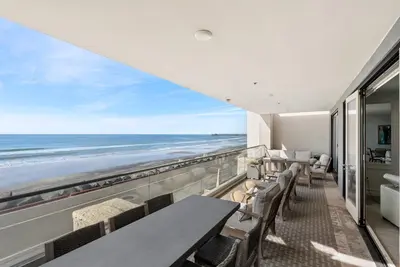 a room with a balcony with a view of the beach at The Penthouse Oceanfront in Oceanside