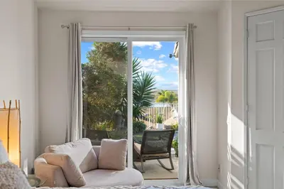 a living room with a couch and a sliding glass door at Carlsbad Retreat by the Sea -30-Night Minimum in Carlsbad