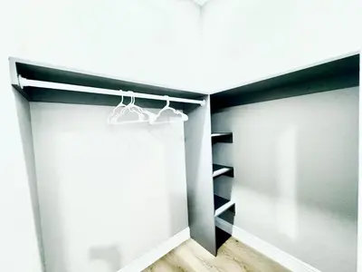 a walk in closet with black shelves and white walls at Escondido Back Unit by sdstay in Escondido