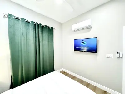 a bedroom with a bed and a tv on a wall at Escondido Back Unit by sdstay in Escondido