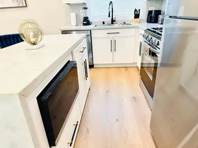 a kitchen with white cabinets and a wooden floor at Escondido Back Unit by sdstay in Escondido
