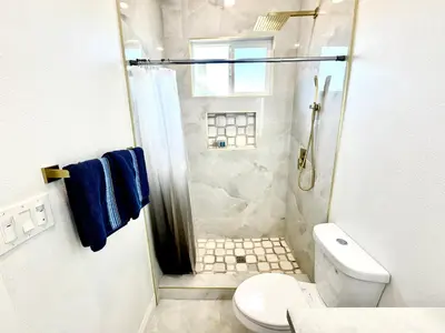 a white bathroom with a shower and a toilet at Escondido Back Unit by sdstay in Escondido