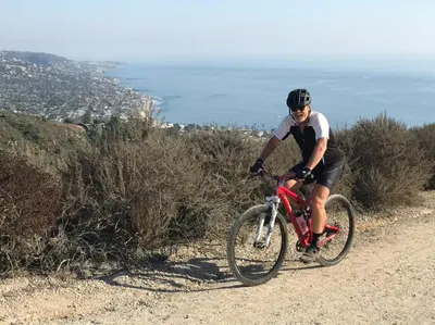 a man riding a bike on a dirt road at Classic Laguna Cottage in Laguna Beach