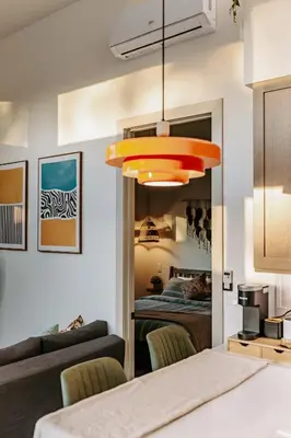a bedroom with a bed and a large orange light fixture at Chic Casita w BBQ, Patio, Backyard - 4 min to SDSU, 15 mins to beach, Unit B in La Mesa
