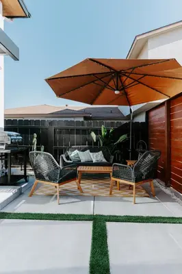 a patio with a table and chairs and an umbrella at Chic Casita w BBQ, Patio, Backyard - 4 min to SDSU, 15 mins to beach, Unit B in La Mesa