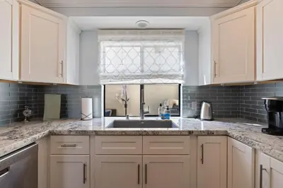 a kitchen with white cabinets and a sink at Carlsbad's Hidden Escape in Carlsbad