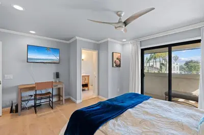 a bedroom with a bed and a desk and a ceiling fan at Carlsbad's Hidden Escape in Carlsbad