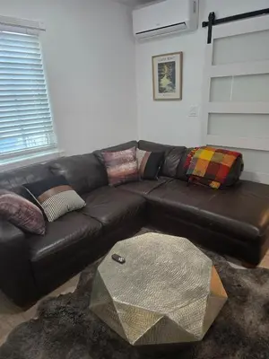 a brown leather couch in a living room at Cozy IBR with Bathtub Hot Tub, Near Golf, Beach, TJ in Bonita