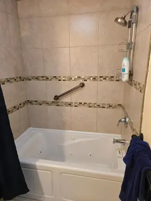 a bathroom with a white tub with a shower at Cozy IBR with Bathtub Hot Tub, Near Golf, Beach, TJ in Bonita