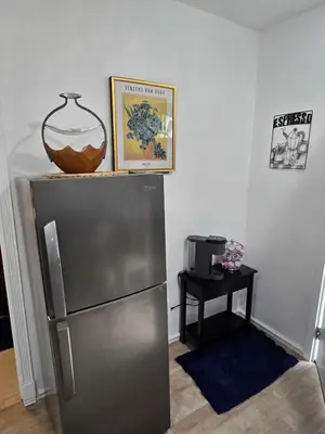 a refrigerator in a room with a table and a picture at Cozy IBR with Bathtub Hot Tub, Near Golf, Beach, TJ in Bonita