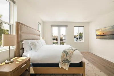 a white bedroom with a large bed and windows at Airy Ocean Beach Home with Coastal Views in San Diego