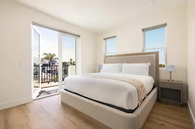 a bedroom with a large bed and a balcony at Airy Ocean Beach Home with Coastal Views in San Diego