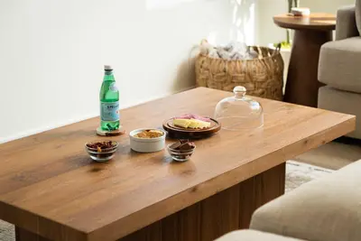 a wooden coffee table with a bottle and bowls of food at Airy Ocean Beach Home with Coastal Views in San Diego