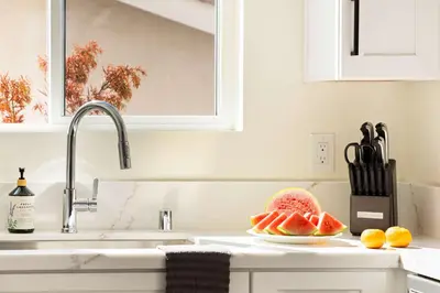 a kitchen sink with a plate of fruit on a counter at Airy Ocean Beach Home with Coastal Views in San Diego