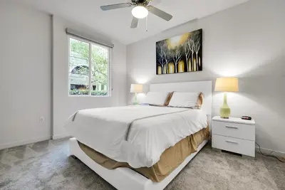 a white bedroom with a bed and a ceiling fan at Global Luxury Suites Mission Valley in San Diego