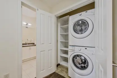 a white laundry room with a washer and dryer at Global Luxury Suites Mission Valley in San Diego