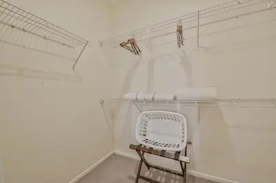a white room with a chair and a shelf at Global Luxury Suites Mission Valley in San Diego