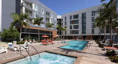 a hotel swimming pool with chairs and a building at Global Luxury Suites Mission Valley in San Diego