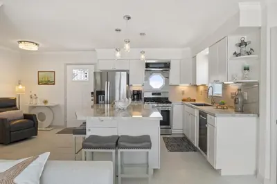 a kitchen with white cabinets and a kitchen island at Luxury Oceanfront steps to Beach & Town, Best views! in Oceanside