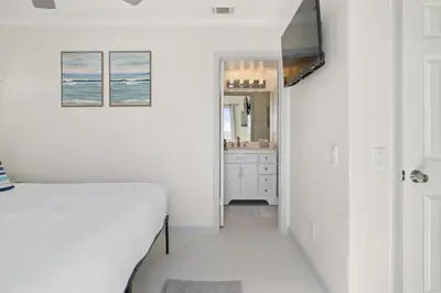 a white hallway with a bed and a bathroom at Luxury Oceanfront steps to Beach & Town, Best views! in Oceanside