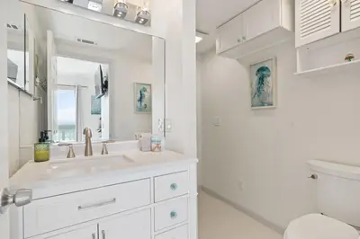 a white bathroom with a sink and a toilet at Luxury Oceanfront steps to Beach & Town, Best views! in Oceanside