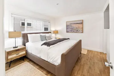 a bedroom with a large bed and a window at Oceanfront La Jolla Cove Condo in San Diego