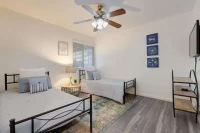 a living room with two beds and a ceiling fan at San Diego 4-Bedroom Home with POOL and Jacuzzi in Rancho Bernardo